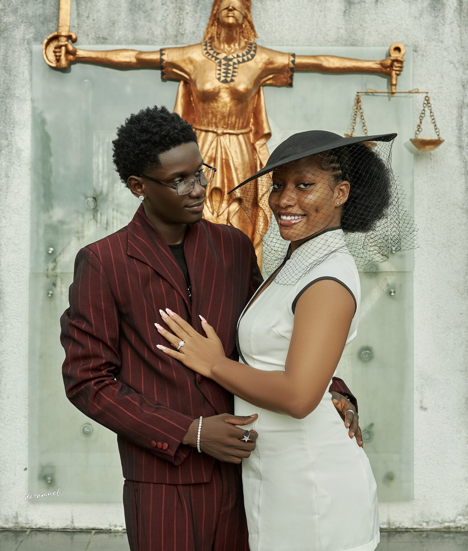 The couple close together by the statue